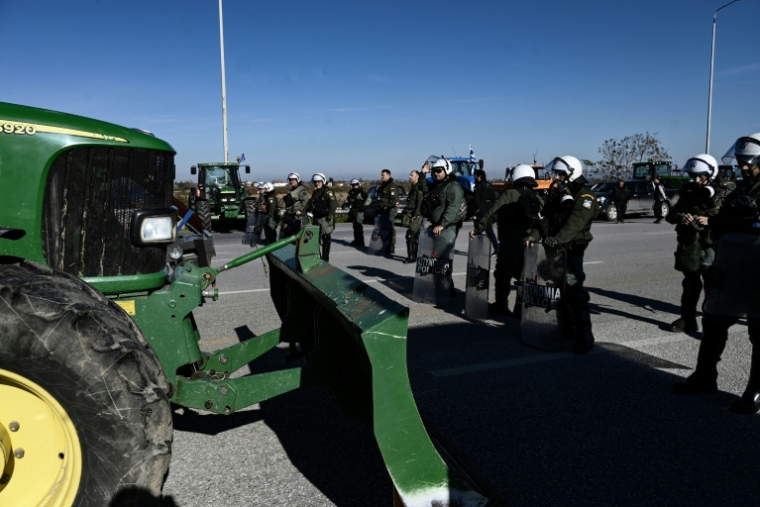 La police grecque sur une route nationale bloquée par des agriculteurs protestant contre les retards de versement de subventions de l'UE suite à un scandale de fraudes, le 1er décembre 2025 près de Thessalonique (Grèce) ( AFP / Sakis Mitrolidis )