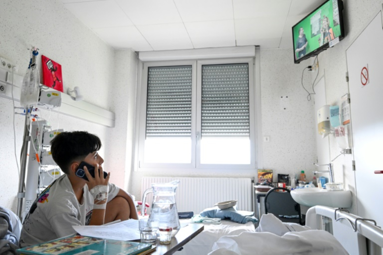 Maël, hospitalisé en chirurgie, passe un appel lors d'une émission télé participative tournée au sein de l'hôpital pour enfants de Nancy équipé d'un studio, le 16 septembre 2025 à Vandoeuvre-lès-Nancy, en  Meurthe-et-Moselle ( AFP / Jean-Christophe VERHAEGEN )