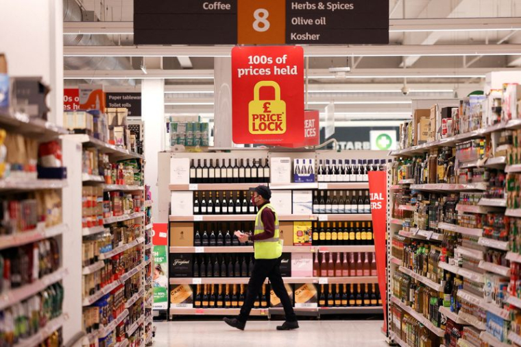 Un employé entre dans un supermarché Sainsbury's à Richmond, dans l'ouest de Londres