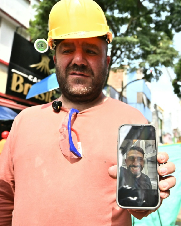 Hernan Giraldo montre une photo de son fils Juan Felipe Giraldo, qu'il recherche toujours à Pereira, en Colombie, le 14 août 2026 ( AFP / Luis ACOSTA )
