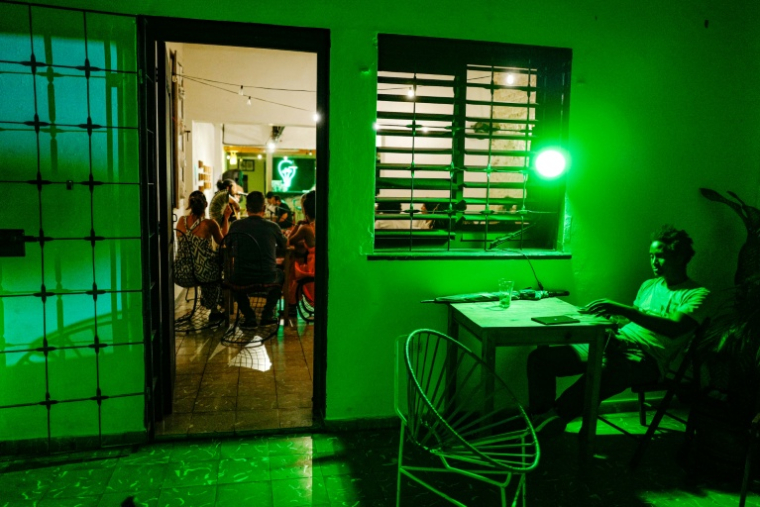 Un jeune homme regarde son téléphone au bar La Bombilla verde, à La Havane, le 27 septembre 2026 ( AFP / ADALBERTO ROQUE )