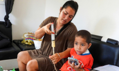 Jessica Rodriguez administre un médicament à son fils Luis Angelo à leur domicile du quartier de Santa Fe à La Havane, le 2 juillet 2025 à Cuba ( AFP / ADALBERTO ROQUE )