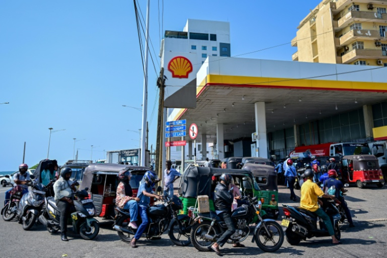 Des motoyclistes font la queue pour prendre du carburant à une station-service de Wellawatte, près de Colombo, le 16 mars 2026 au Sri Lanka  ( AFP / Ishara S. KODIKARA )
