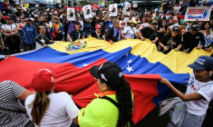 Des manifestants brandissent un drapeau vénézuélien géant lors d'un rassemblement en soutien au président vénézuélien déchu Nicolas Maduro à Caracas, le 10 janvier 2026 ( AFP / Juan BARRETO )