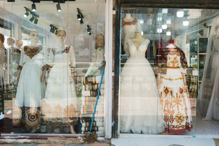 Des netela et des habesha kemis (vêtements traditionnels éthiopiens) dans la vitrine d'un magasin du quartier Shiromeda à Addis Abeba, le 7 octobre 2025 en Éthiopie ( AFP / Sehin Tewabe )