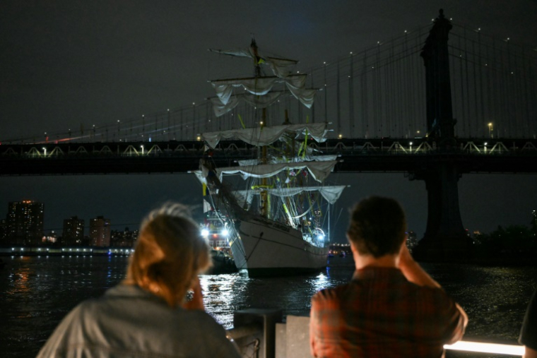 Des personnes regardent un navire-école de la marine mexicaine après qu'il a heurté le pont de Brooklyn à New York, le 17 mai 2025 ( AFP / ANGELA WEISS )