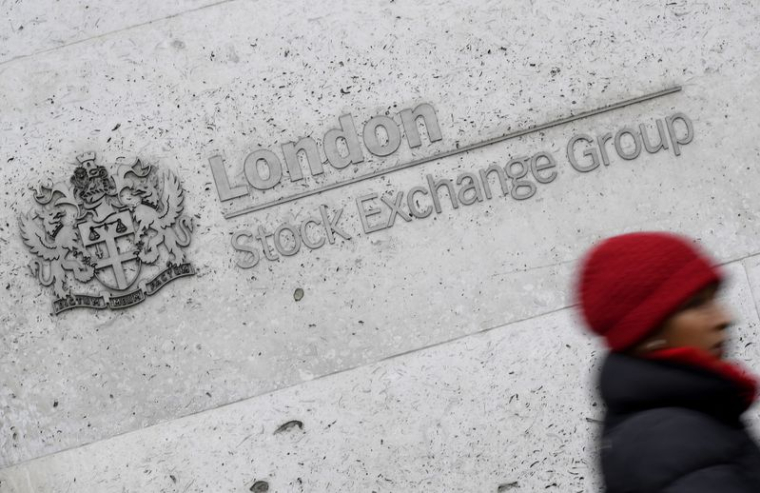 Une femme passe devant le bâtiment de la Bourse de Londres dans la City de Londres, Grande-Bretagne