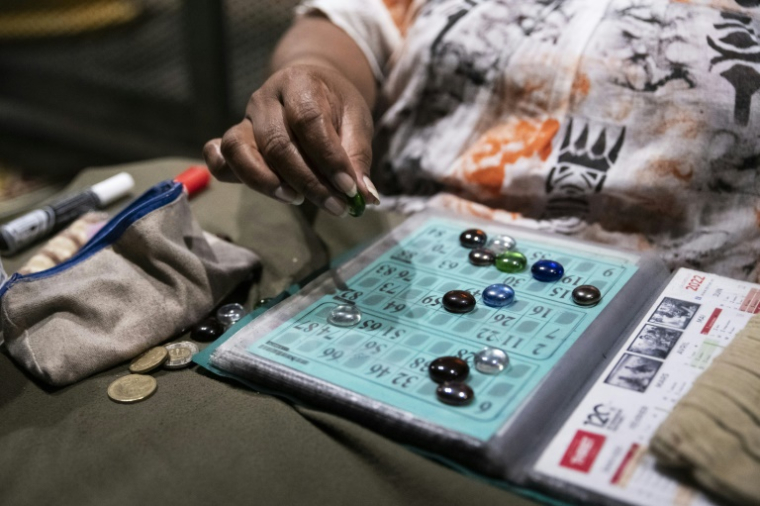 Une participante joue au bingo sur le parking d'un centre commercial désaffecté, dans le quartier de Rivière-Salée à Nouméa, en Nouvelle-Calédonie, le 8 mai 2025 ( AFP / Delphine MAYEUR )
