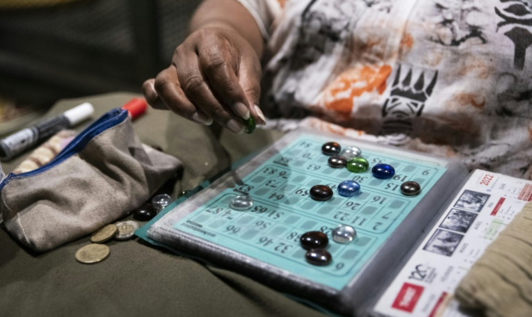 Une participante joue au bingo sur le parking d'un centre commercial désaffecté, dans le quartier de Rivière-Salée à Nouméa, en Nouvelle-Calédonie, le 8 mai 2025 ( AFP / Delphine MAYEUR )