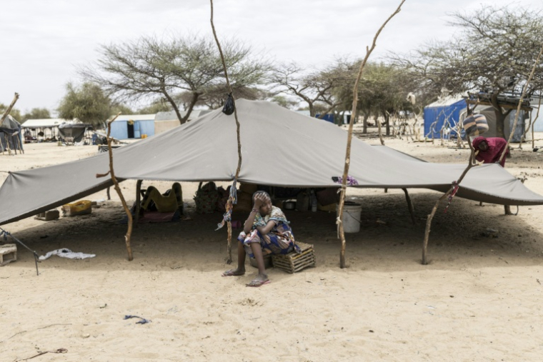 Un réfugié est assis devant une tente dans un campement de fortune à Doueinkara (Mauritanie), près de la frontière entre la Mauritanie et le Mali, le 28 avril 2026  ( AFP / PATRICK MEINHARDT )