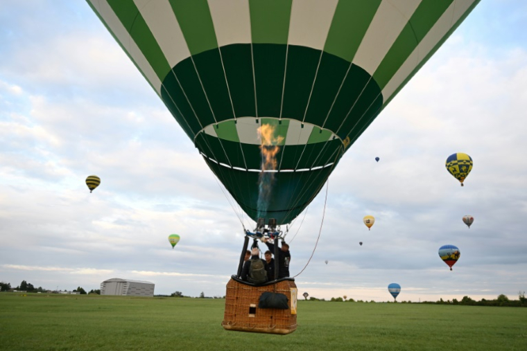 Une montgolfière survole la base de Chambley-Bussières, en Meurthe-et-Moselle, à l'occasion du festival Enenvol, le 28 juillet 2025 ( AFP / Jean-Christophe VERHAEGEN )