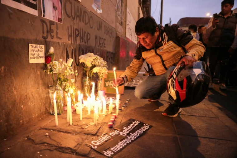 Un homme allume des bougies lors d'une veillée à la mémoire du manifestant Eduardo Ruiz, décédé lors d'une manifestation contre le président par intérim du Pérou, José Jeri, à Lima, le 16 octobre 2025 ( AFP / CONNIE FRANCE )