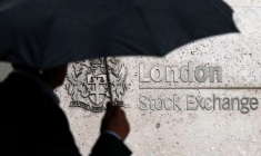 Un homme s'abrite sous un parapluie alors qu'il passe devant la Bourse de Londres