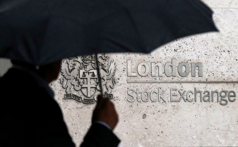 Un homme s'abrite sous un parapluie alors qu'il passe devant la Bourse de Londres