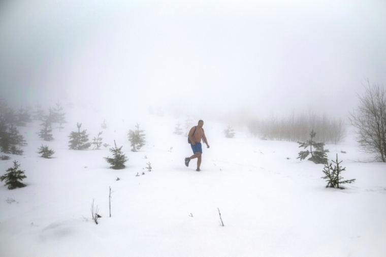 L'archéologue serbe Vladimir Stevanovic marche dans une épaisse couche de neige, en short et chaussures de randonnée, sur le mont Besna Kobila, près de la ville de Vranje, le 30 janvier 2026 en Serbie ( AFP / Oliver BUNIC )