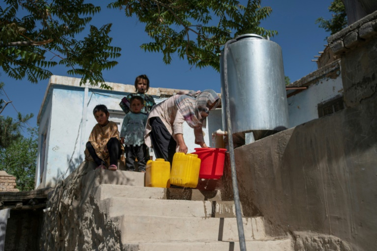 Une habitante récupère de l'eau potable à partir d'une citerne à Kaboul, le 27 avril 2025 en Afghanistan ( AFP / Wakil KOHSAR )