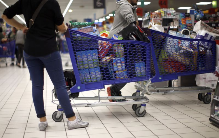 Des clients font leurs courses dans un hypermarché Carrefour à Nice, à côté de chariots de supermarché
