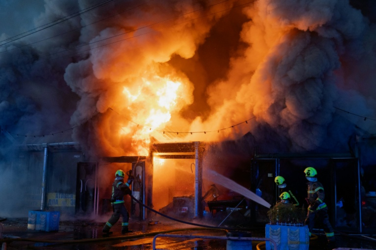 Des pompiers ukrainiens luttent contre un incendie après une attaque aérienne russe, le 16 août 2026 à Kiev  ( AFP / Tetiana DZHAFAROVA )