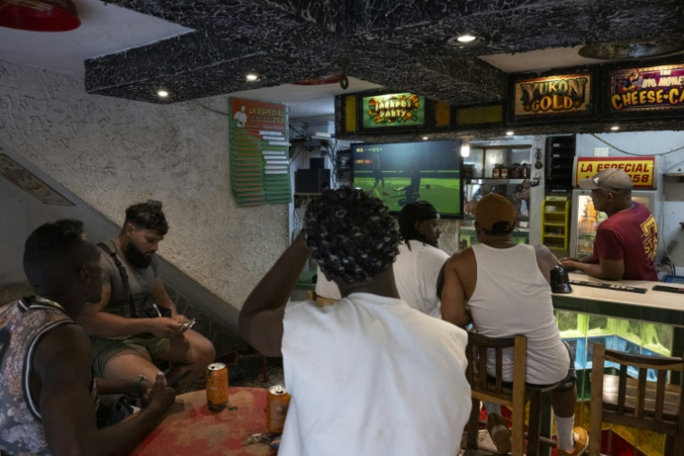 Des Cubains devant le match Maroc-Brésil dans un bar de Centro Habana, à La Havane, le 13 juin 2026 ( AFP / Pablo PORCIUNCULA )