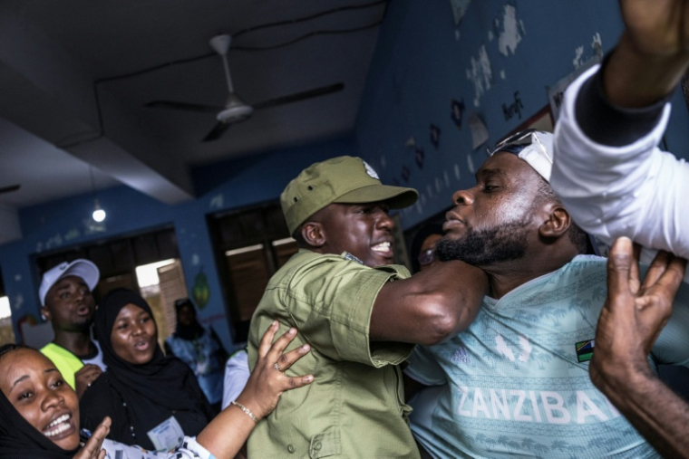 Un policier tanzanien arrête un homme accusé par des responsables électoraux d'avoir tenté de frauder dans un bureau de vote de Stone Town (Tanzanie), le 29 octobre 2025 ( AFP / MARCO LONGARI )