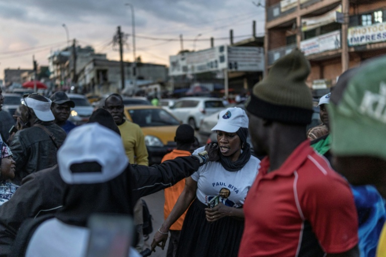 Une femme portant un t-shirt du président sortant du Cameroun, Paul Biya, est prise à partie par des chauffeurs de moto-taxis soutenant le candidat d'opposition Issa Tchiroma, à Yaoundé le 11 octobre 2025 ( AFP / MARCO LONGARI )