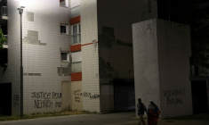 Des habitants passent devant des phrases écrites sur les murs des immeubles de Nanterre, le quartier du jeune de 17 ans tué par un policier lors d'un contrôle routier