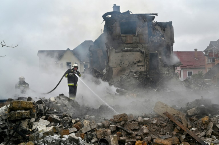 Des pompiers interviennent sur un incendie dans des maisons endommagées par une frappe russe dans la région de Kiev, le 25 mai 2025 en Ukraine ( AFP / Sergei SUPINSKY )