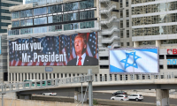 Un panneau d'affichage à Tel-Aviv montre une photo du président américain Donald Trump avec l'inscription "Merci, président Trump" et un autre arbore le drapeau israélien, après l'accord sur Gaza, le 9 octobre 2025 ( AFP / Jack GUEZ )