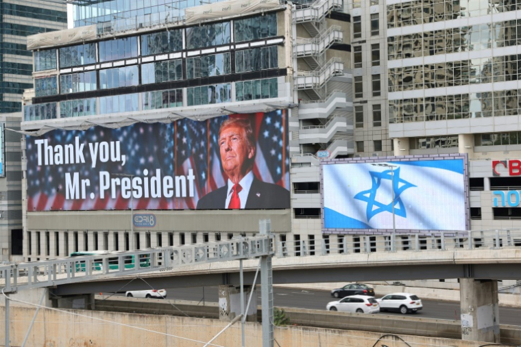 Un panneau d'affichage à Tel-Aviv montre une photo du président américain Donald Trump avec l'inscription "Merci, président Trump" et un autre arbore le drapeau israélien, après l'accord sur Gaza, le 9 octobre 2025 ( AFP / Jack GUEZ )