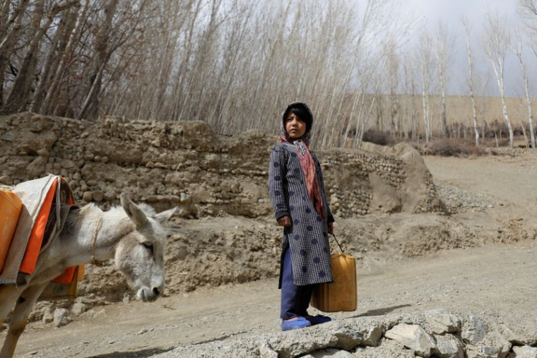 Une jeune fille avec un récipient d'eau vide, en Afghanistan