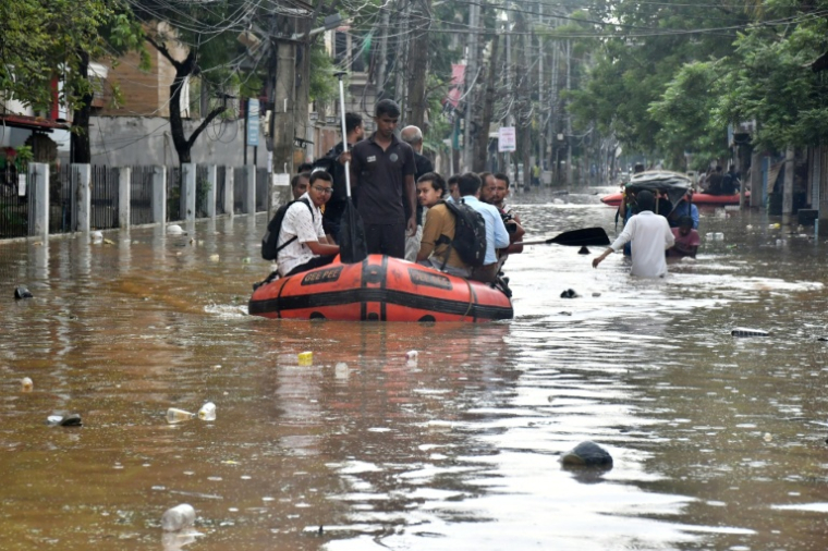 Des membres du Fonds d'intervention d'urgence de l'État (SDRF) portent secours des habitants d'une zone inondée à la suite de fortes pluies de mousson à Guwahati, dans l'Assam, en Inde, le 4 août 2026. ( AFP / Biju BORO )