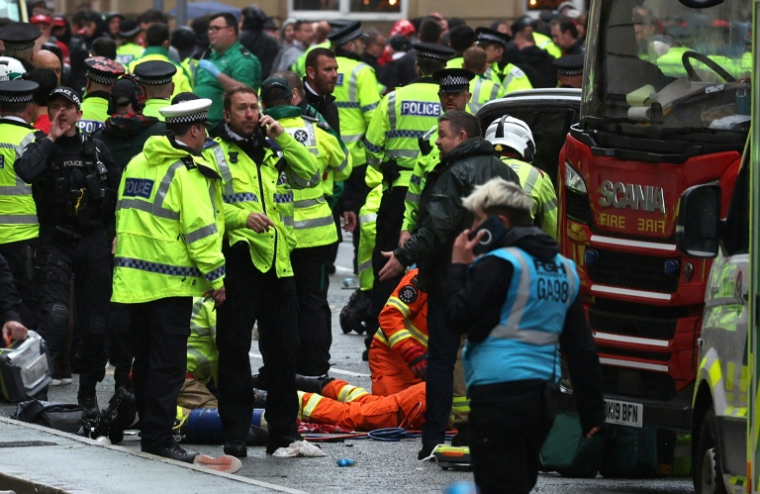 Des soignants à l'intérieur d'un cordon de police sur les lieux d'un incident, en marge d'un défilé pour la victoire de Liverpool en Premier League, à Liverpool, le 26 mai 2025 ( AFP / Darren Staples )