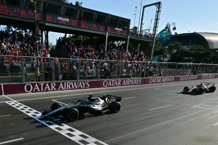 George Russell passe la ligne d'arrivée du GP d'Azerbaïdjan victorieux au volant de sa Mercedes devant la Red Bull du Néerlandais Max Verstappen (2e) le 26 septembre 2026 à Bakou  ( POOL / Andrej ISAKOVIC )