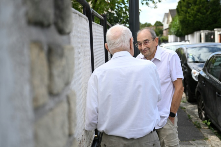 Stanislas Melka, bénévole de l'association Petits Frères des pauvres, en discussion avec un retraité de Colombes (Hauts-de-Seine), le 5 août 2026 ( AFP / Lou BENOIST )