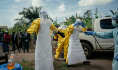 Des membres de la Croix-Rouge congolaise, en combinaison de protection, se désinfectent après avoir préparé le cercueil d'une femme soupçonnée d'être décédée de la maladie à virus Ebola, le 7 juin 2026 à Bunia, en RDC ( AFP / Jospin Mwisha )