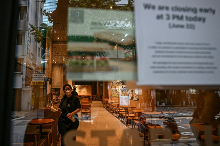 Des employés nettoient un café Starbucks lors d'une fermeture anticipée à Séoul, le 22 juin 2026 ( AFP / Jade GAO )
