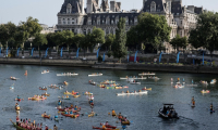 Des kayaks, des paddles et des barques naviguent sur la Seine, avec l'Hôtel de Ville de Paris en arrière-plan, pour marquer le premier anniversaire des Jeux olympiques de Paris 2024, le 26 juillet 2025 ( AFP / STEPHANE DE SAKUTIN )