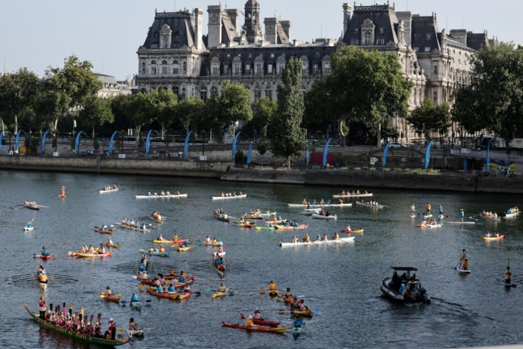 Des kayaks, des paddles et des barques naviguent sur la Seine, avec l'Hôtel de Ville de Paris en arrière-plan, pour marquer le premier anniversaire des Jeux olympiques de Paris 2024, le 26 juillet 2025 ( AFP / STEPHANE DE SAKUTIN )