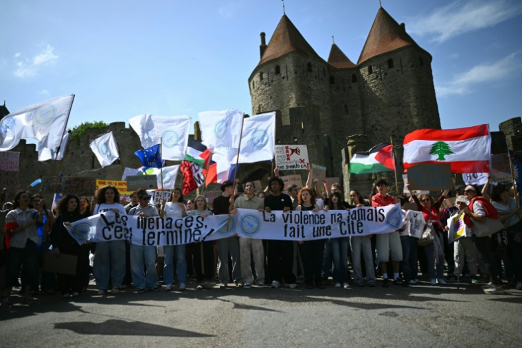 Des drapeaux libanais, palestinien et de l'UE lors d'une manifestation devant la citadelle médiévale, à l'appel du collectif "Nous Carcassonne", pour protester contre les décisions prises par le maire Rassemblement National Christophe Barthès, le 29 avril 2026 à Carcassonne, dans l'Aude ( AFP / LIONEL BONAVENTURE )