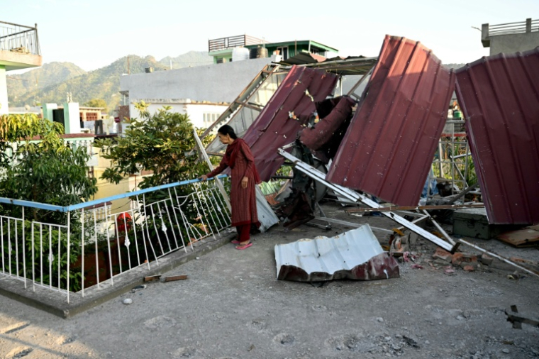 Une femme se tient près de son habitation endommagée par un bombardement pakistanais, à Poonch, au Cachemire indien, le 14 mai 2025 ( AFP / Money SHARMA )