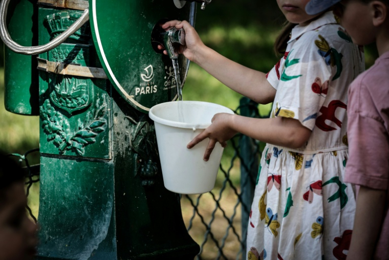Une enfant remplit un seau d'eau à Paris, lors d'une vague de chaleur qui touche plusieurs pays européens, le 25 mai 2026 ( AFP / STEPHANE DE SAKUTIN )