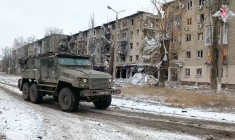 Un véhicule militaire russe passe devant des bâtiments résidentiels endommagés dans la ville d'Avdiivka