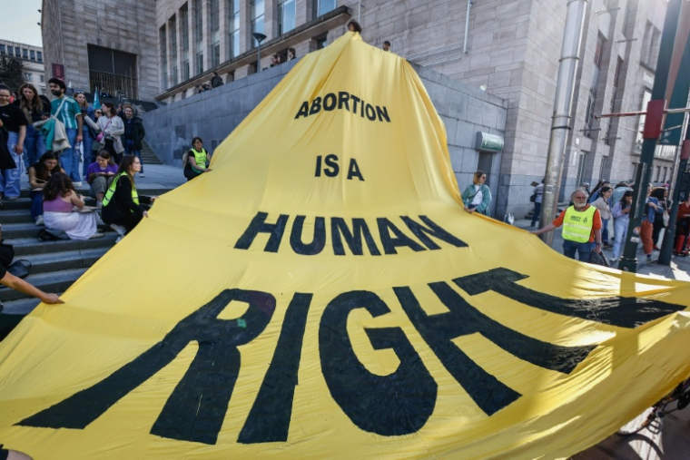 "L'avortement est un droit humain", lit-on sur une banderole déployée à Bruxelles, le 8 mars 2025, à l'occasion de la journée internationale des droits des femmes ( AFP / Simon Wohlfahrt )