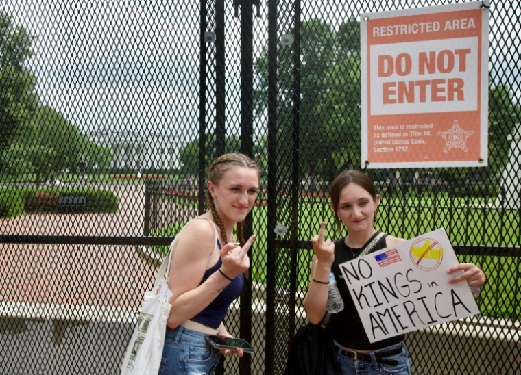 De jeunes manifestantes tiennent une pancarte contre Donald Trump, aux abords de la Maison Blanche, le 14 juin 2025 à Washington ( AFP / Amid FARAHI )