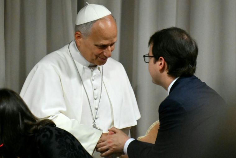 Christopher Olah, le cofondateur d'Anthropic; à droite, salue le pape Léon XIV lors de sa présentation de la première encyclique jamais consacrée à l'IA, "Magnifica humanitas", au Vatican le 25 mai 2026 ( AFP / Alberto PIZZOLI )