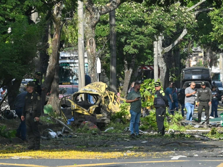 Des membres de la police colombienne inspectent la zone d'une explosion au camion piégé à Cali, en Colombie, le 21 août 2025 ( AFP / Oswaldo Páez )