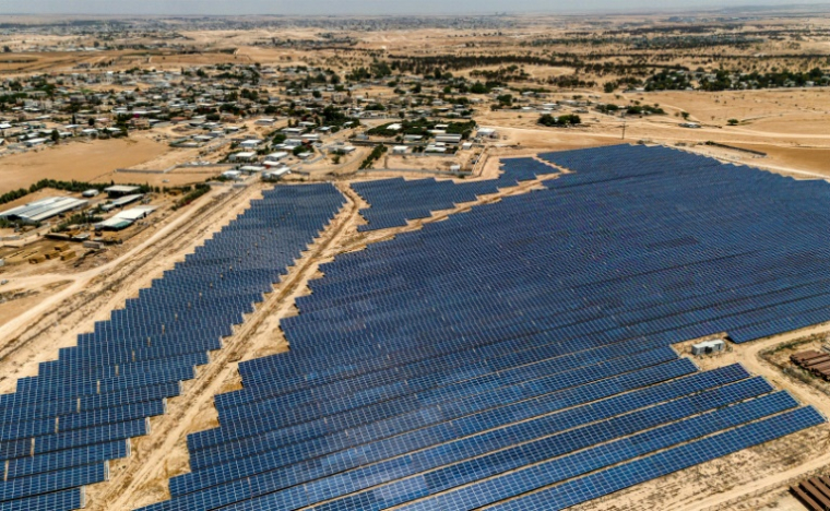 Vue aérienne de panneaux solaires dans une centrale électrique pour la communauté bédouine du village de Tirabin al-Sana, dans le désert du Néguev, au sud d'Israël, le 11 juin 2025 ( AFP / Menahem KAHANA )