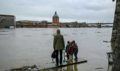 Des personnes observent la Garonne après de fortes pluies, à Toulouse, le 11 février 2026 ( AFP / Ed JONES )