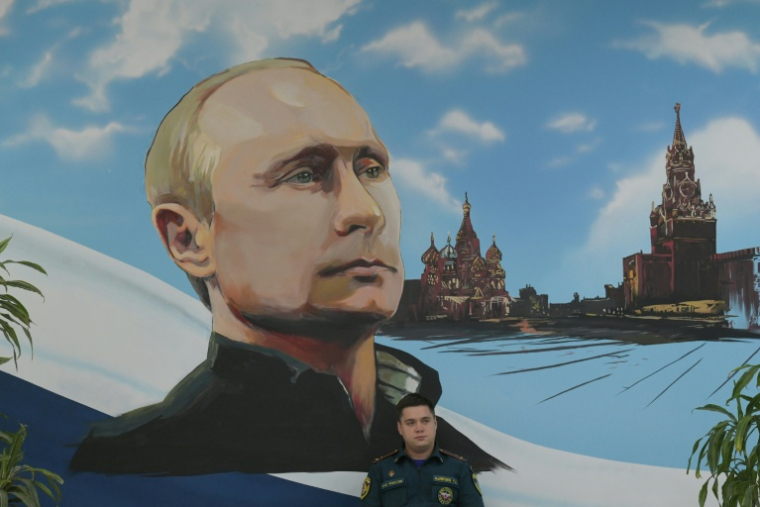 Un panneau mural représentant Vladimir Poutine et la Place rouge, le 20 septembre 2026 dans un bureau de vote de Donetsk, dans les territoires ukrainiens occupés par la Russie ( AFP / STRINGER )