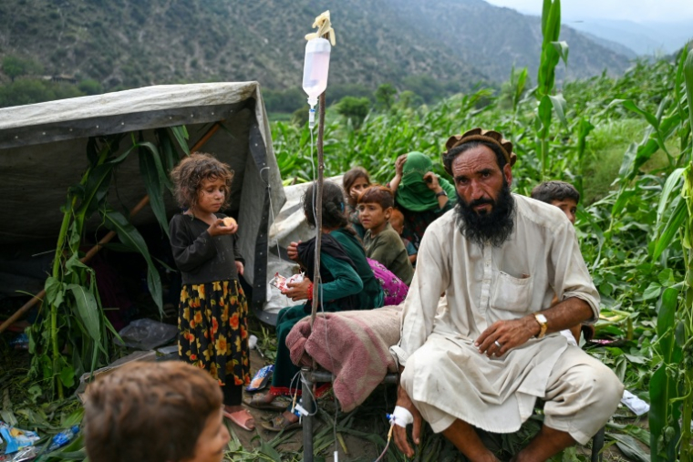 Un Afghan blessé reçoit une perfusion dans un champ de maïs à la suite de séismes dans le village de Mazar Dara, situé dans le district de Nurgal (province de Kounar), dans l'est de l'Afghanistan, le 1er septembre 2025 ( AFP / Wakil Kohsar )